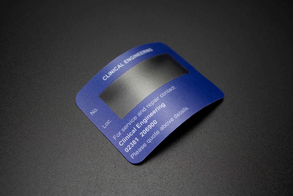 Royal blue coloured plastic label with white text information and large clear window