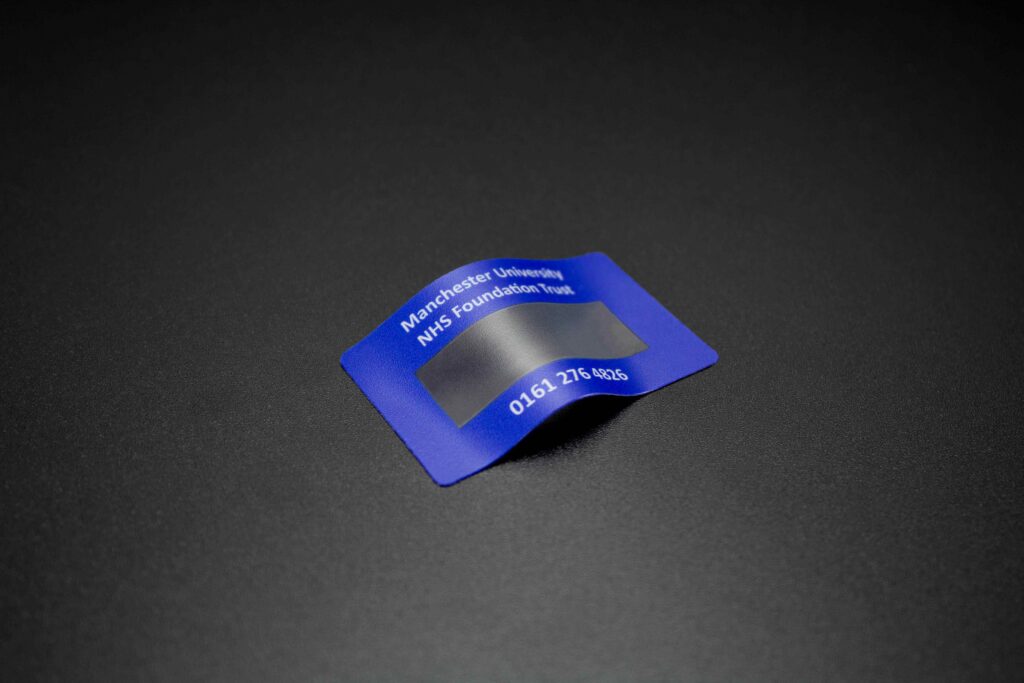 Blue plastic asset label with white text and clear window