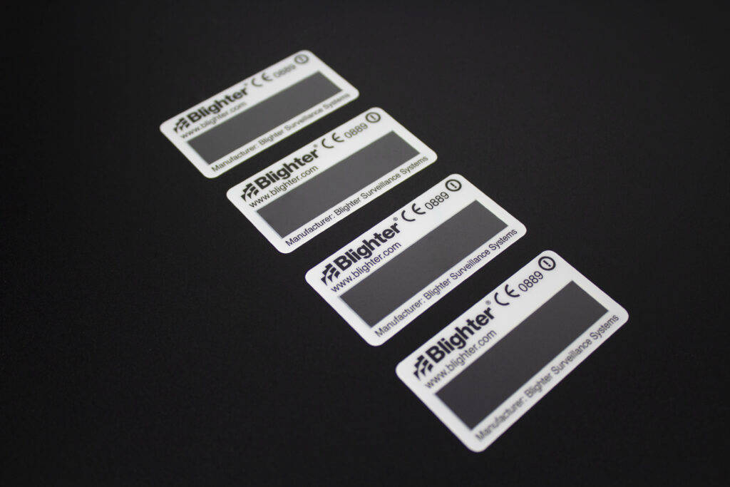 Row of white asset labels with black text and logo and clear window for electronics industry